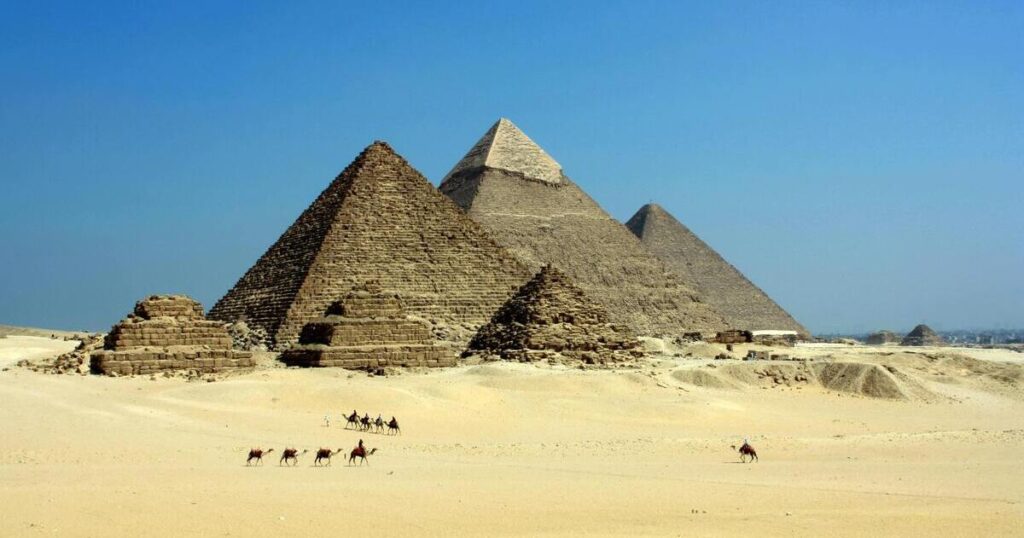 Pyramids in desert under blue sky